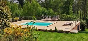 Fosses-La-VilleDomaine Le Haut-Vent的庭院内一个带甲板和椅子的游泳池