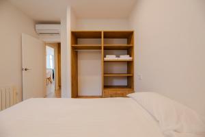 a bedroom with a white bed and a closet at Apartamento Almadraba in Roses +22 photos