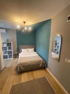 1 dormitorio con cama y pared azul en Rooms, en Bacău