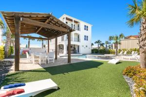 Un patio con mesa y sillas y un edificio. en Blue Whale Your Luxury Beach Escape, en Destin