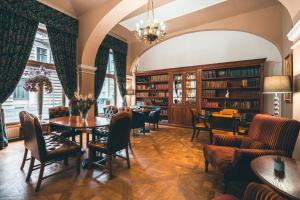 فندق جوليان في براغ: مكتبة فيها طاولة وكراسي ورفوف كتب