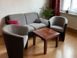 a living room with a couch and two chairs and a table at Ferienwohnung Gleißner Hartmann in Sangerhausen