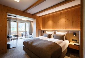 a large bedroom with a large bed and a desk at NOVA Moments Boutique Hotel in Pertisau