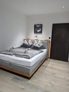 a bedroom with a large bed with a wooden frame at Apartment Talblick in Bramberg am Wildkogel