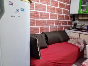 - un canapé rouge dans une cuisine avec un mur en briques dans l'établissement Casinhas no Interior de MG, à Antônio Prado