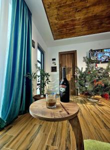 Una botella de vino en una mesa en una habitación con un árbol de Navidad en WoodStar/ტყის ვარსკვლავი en Ambrolauri