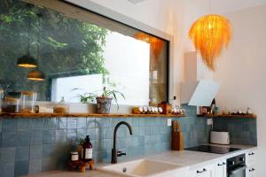 eine Küche mit Spüle und Fenster in der Unterkunft Superbe maison à 5 min de Bordeaux in Le Bouscat + 7 Fotos