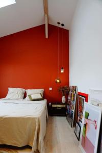 ein Schlafzimmer mit einer orangefarbenen Wand und einem Bett in der Unterkunft Superbe maison à 5 min de Bordeaux in Le Bouscat