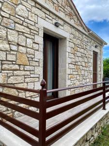 una casa de piedra con una valla de madera en un porche en Villa Maria 1, en Gliki