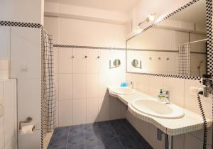 a white bathroom with a sink and a mirror at Dünenvilla 4 in Thiessow in Göhren +13 photos