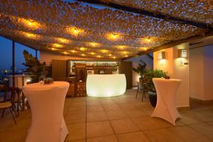 een restaurant met verlichting aan het plafond en tafels bij Hotel Bécquer in Sevilla