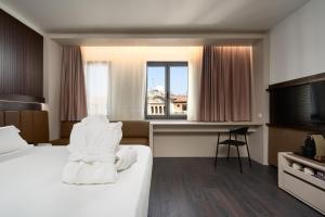 a hotel room with a bed and a window at Hotel Bécquer in Seville
