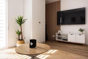 a living room with a table and a flat screen tv at Chartres - Le Saint Pierre in Chartres