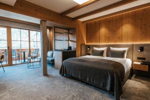 ein Schlafzimmer mit einem großen Bett in einem Zimmer mit Holzwänden in der Unterkunft NOVA Moments Boutique Hotel in Pertisau