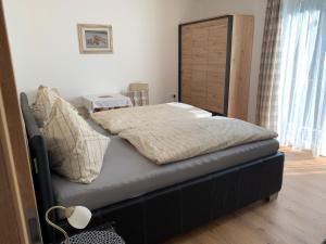 1 dormitorio con 1 cama grande y cabecero de madera en Chalet Ester, en Bad Hofgastein