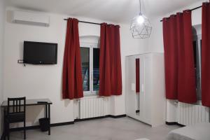 ジェノヴァにあるCasa dei nonniのリビングルーム(赤いカーテン、テレビ付)