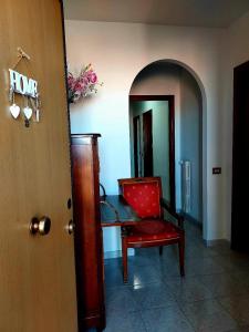 Zimmer mit einem Tisch und einem roten Stuhl in der Unterkunft Tina'home in Selcetta