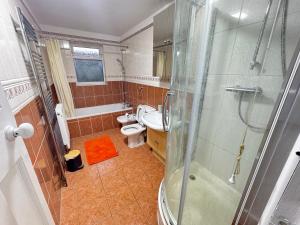 a bathroom with a shower and a toilet and a sink at Golden Villa in Uxbridge