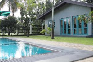 een huis met een zwembad naast een gebouw bij J Villa in Gampaha