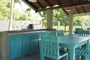 an outdoor kitchen with a blue table and chairs at J Villa in Gampaha