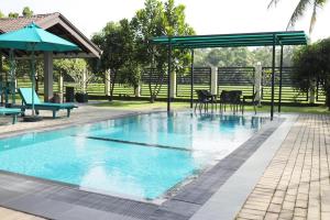 a swimming pool with a picnic table and an umbrella at J Villa in Gampaha