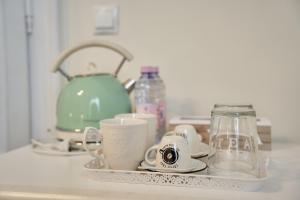 a kitchen counter with a tray with cups and a tea kettle at Charma Residence in Sibiu +41 photos