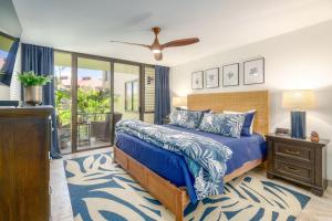 a bedroom with a blue bed and a balcony at Kamaole Sands 7-100 in Wailea +34 photos