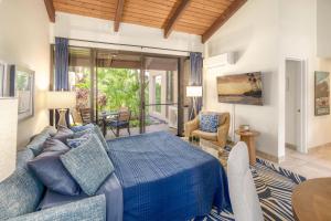 a bedroom with a blue bed and a table and chairs at Kamaole Sands 7-100 in Wailea