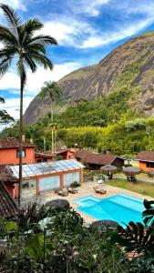 a resort with a swimming pool and a mountain at Kastel Pedra Bonita in Petrópolis