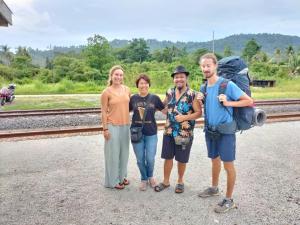 eine Gruppe von Personen, die neben einer Eisenbahnstrecke stehen in der Unterkunft Betik Garden Home in Macang