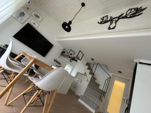 a living room with white chairs and a flat screen tv at GOODMOOSE - Good Mood House in Palanga +12 photos