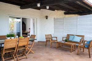 a patio with chairs and a table and a couch at Ca Cele Viola by Klodge in Olbia