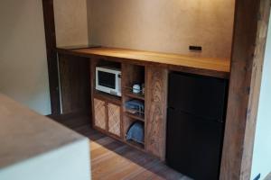 un centro de entretenimiento de madera con microondas y TV en La casa di Endo - Vacation STAY 17606v, en Nishinoomote