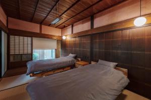 2 Betten in einem Zimmer mit Holzwänden in der Unterkunft La casa di Endo - Vacation STAY 17606v in Nishinoomote