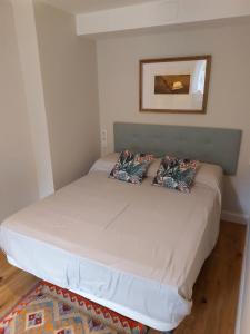 a bed with two pillows on it in a room at Casona del Sol El Retorno II - RECIEN REFORMADO in Lastres