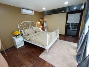 ein Schlafzimmer mit einem weißen Bett in einem Zimmer in der Unterkunft The Syawal in Johor Bahru