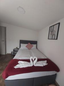 a bed with two towels in the shape of hearts at Panda Rooms in Maribor