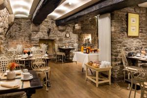 un restaurant avec des murs en pierre, des tables et des chaises dans l'établissement Hotel Elizabeth - Intra Muros, à Saint-Malo
