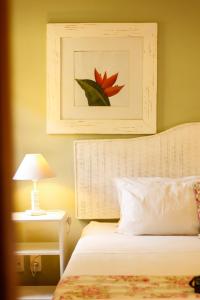 ein Schlafzimmer mit einem Bett und einem Bild an der Wand in der Unterkunft Pousada Blanca Inn in Búzios