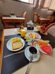 a table with plates of breakfast foods and a cup of coffee at Hotel Bella Paulista in Sao Paulo