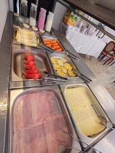 una línea de buffet con diferentes tipos de carne y queso en Hotel Bella Paulista, en São Paulo