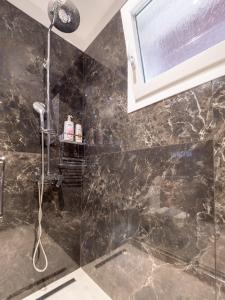 baño con ducha con pared de mármol negro en THE VIEW HOUSE en Pelekas