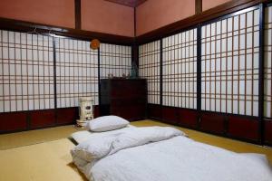 een kamer met een bed in een kamer met ramen bij Oyamanoyado Michitsuji in Otoyocho