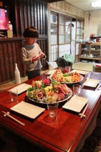 a boy standing at a table with two plates of food at Oyamanoyado Michitsuji in Otoyocho