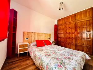 Un dormitorio con una cama con almohadas rojas. en PORT AMBAR - Apartamento en la Marina de Empuriabrava - balcón con vistas al canal - playa - wifi, en Empuriabrava