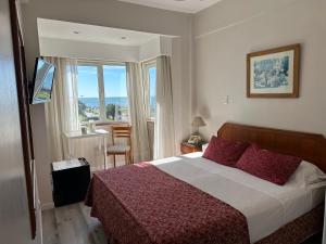 a bedroom with a large bed and a large window at Hotel Guerrero in Mar del Plata