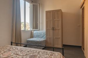 a bedroom with a bed and a chair and a cabinet at Parco vacanze e appartamenti Pfirsich in Borghetto Santo Spirito