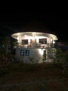 Una casa blanca por la noche con luces encendidas. en Cuestas Beach Resort and Restaurant, en Badian