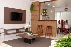 - un salon avec une télévision et une table dans l'établissement Mar Y Suites, à Cabo Frio