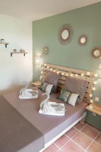 ein Schlafzimmer mit einem großen Bett mit zwei Kissen in der Unterkunft Le Pti' Zandoli Anse des Rochers in Saint-François